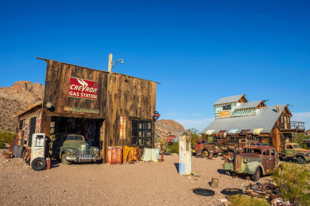 Nelson, Nevada, USA. Old wooden houses, vintage fuel pumps and rusty car wrecks in the Nelson ghost town located in the Eldorado Canyon and surrounded by Eldorado Mountains.