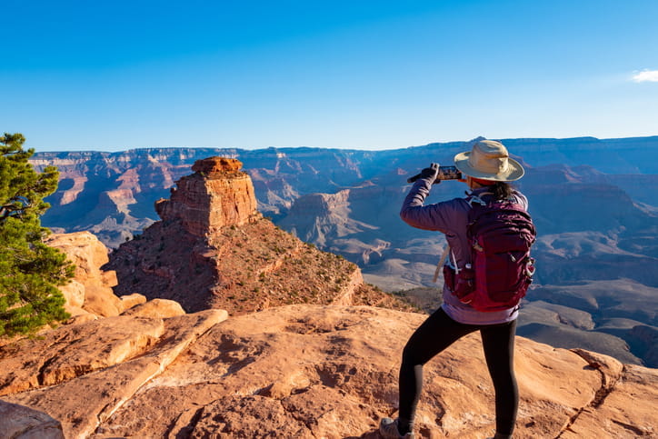 A tourist taking a photo while exploring the Grand Canyon. 
