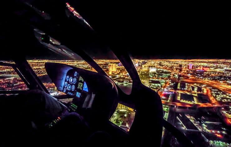 The cockpit view and a defocused aerial view of Las Vegas at night.