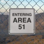 A fence with a sign that reads: "Entering Area 51."