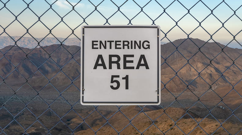 A fence with a sign that reads: "Entering Area 51."